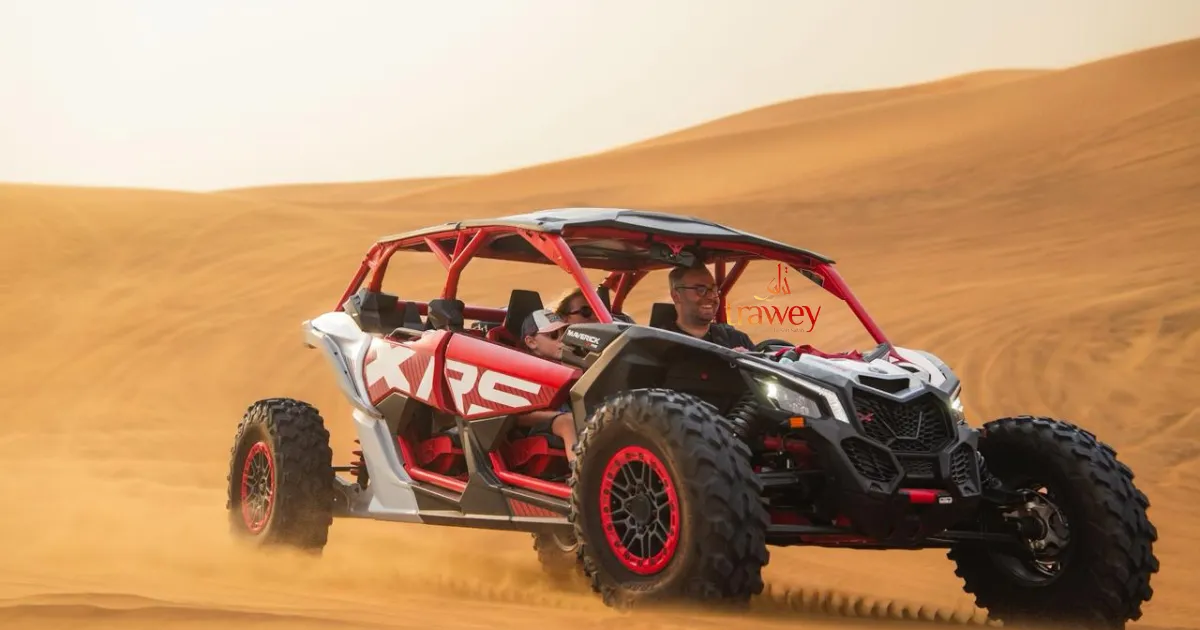 Tourists riding a red and black dune buggy over golden sand dunes in the Dubai desert safari.