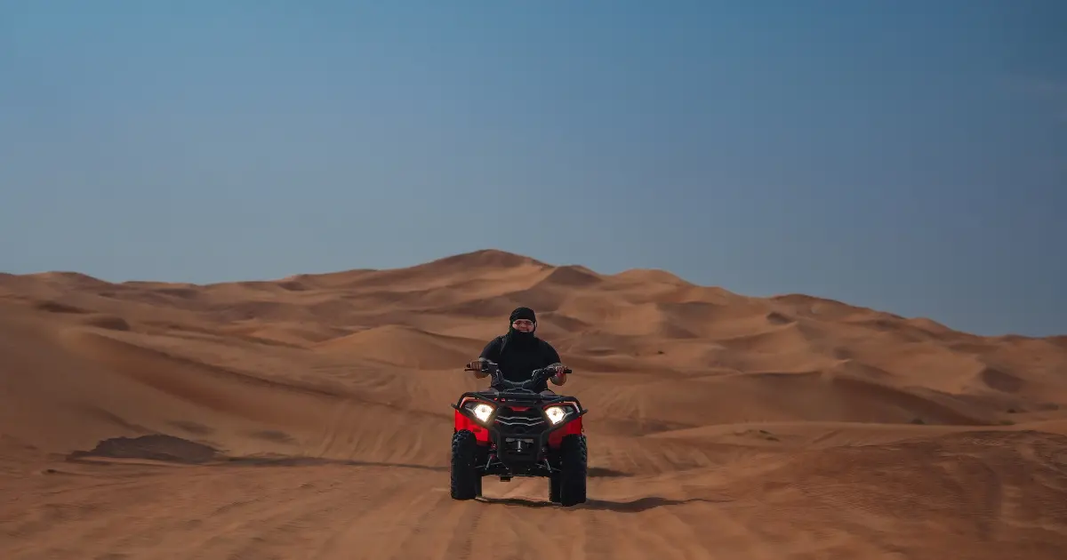 A solo traveler enjoying a safe and thrilling quad bike ride in the Dubai desert.