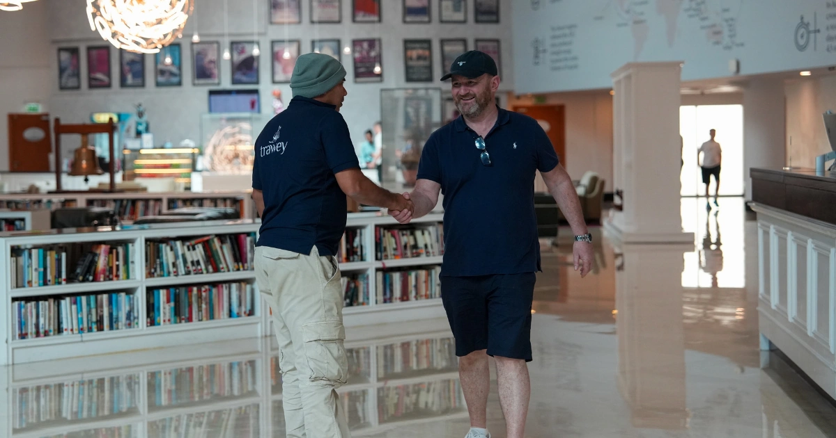 Trawey Tours guide greeting an international traveler during a Dubai layover airport pickup and transfer service.