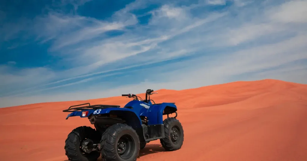 Blue quad bike on red sand dunes during a desert safari in Dubai, a popular activity available during Ramadan 2026.