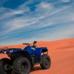 Blue quad bike on red sand dunes during a desert safari in Dubai, a popular activity available during Ramadan 2026.