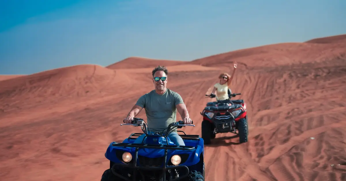 Quad biking adventure in Dubai desert dunes; consider safety tips for back pain relief.